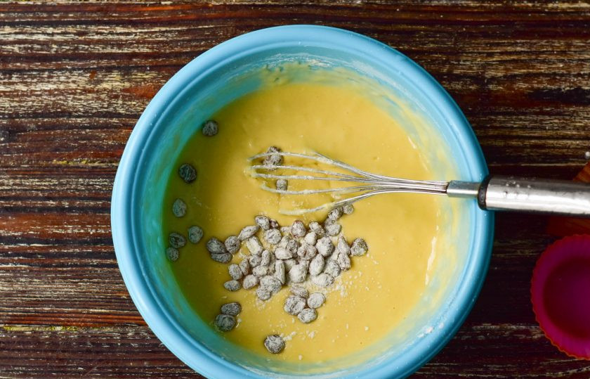 1. Этап. Сливочные капкейки: Венчиком хорошо разотрите все комочки в тесте, всыпьте изюм, который предварительно обваляйте в муке.