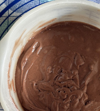 1. Этап. Шоколадный пирог с маскарпоне: Просеять смесь порциями поверх яичной массы с маскарпоне. Аккуратно перемешать мучную смесь, прежде чем просеивать следующую порцию.