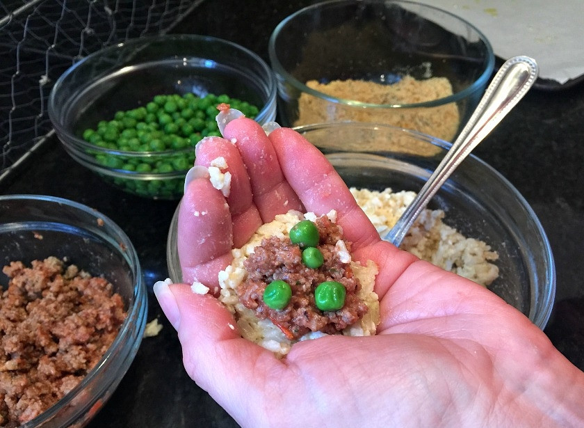 1. Этап. Рисовые колобки с мясом: 2. Возьмите небольшое количество риса и сформируйте небольшую лепешку, внутрь положите немного фарша, горошек.