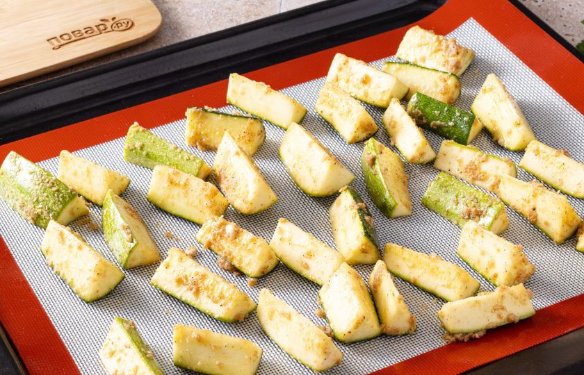 1. Этап. Кабачки с чесноком в духовке: Выложите овощи в один слой на силиконовый коврик или пергамент. Выпекайте 20-25 минут в разогретой до 180 градусов духовке.