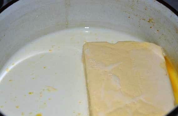 1. Этап. Печенье Конвертики с творогом: Маргарин растопите на огне, добавьте молоко и дрожжи, перемешайте.