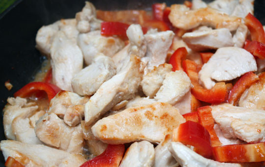 1. Этап. Курица в сливках: Теперь выливаем на сковороду водку, жарим курицу еще минут 5, затем выкладываем нарезанный брусками перец, солим и перчим все, продолжаем жарить пару минут.