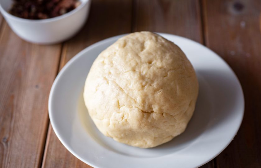 1. Этап. Торт Муравейник с медом: Замесите мягкое тесто, которое не прилипает к рукам. Тесто округлите, оберните в пищевую пленку и отправьте в морозильную камеру на 30 минут — оно должно хорошенько подмерзнуть.