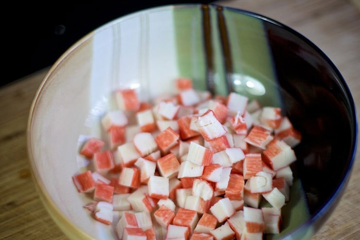 1. Этап. Cалат с крабовыми палочками и фасолью: Нарежьте кубиками крабовые палочки. Выложите в салатницу.