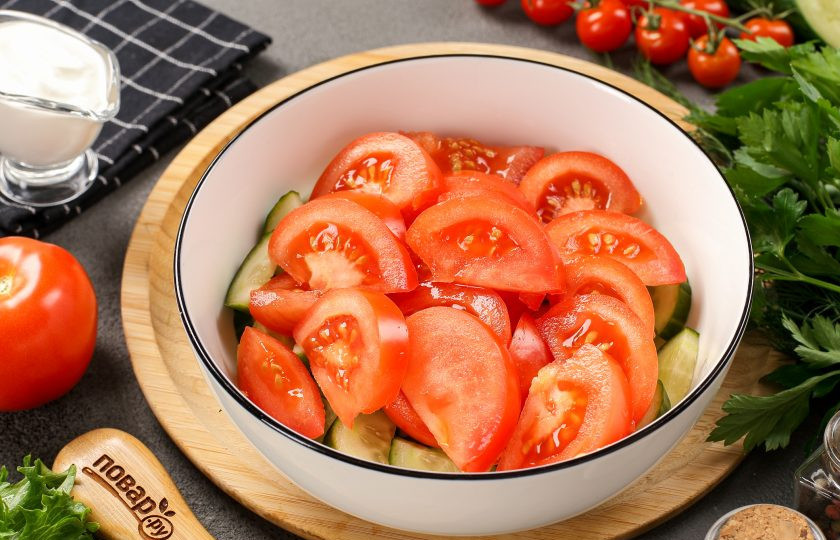 1. Этап. Салат из помидоров и огурцов со сметаной: Добавьте нарезанные дольками помидоры. Если у вас небольшие помидорки, то достаточно разрезать их на 2-4 части.