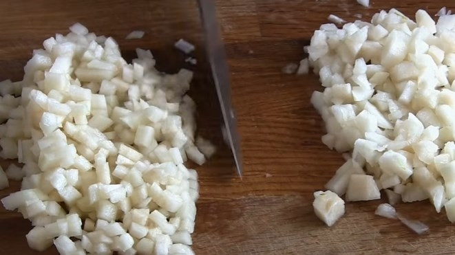 1. Этап. Салат из сельди Рождество: 4. Грушу очистите от кожуры, нарежьте мелким кубиком и разделите на 2 части.