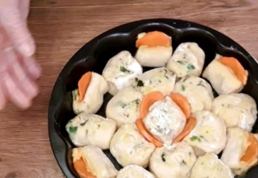 1. Этап. Ленивые пельмени с индейкой и капустой: 15. Смазываем форму (Ф=20 см) для запекания маслом (от обжарки моркови), раскладываем рулетики и украшаем морковью.