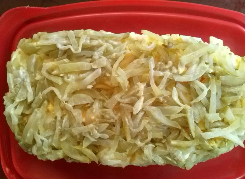 1. Этап. Салат Полковник: 6-й слой - измельченные соленые огурцы, отжатые от жидкости. Покроем ими весь салат со всех сторон. Подравняем углы с помощью широкого ножа или спатулы.