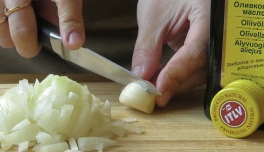 1. Этап. Спагетти с чернилами каракатицы в сливочном соусе: Нарежьте лук полукольцами, чеснок разрежьте пополам.