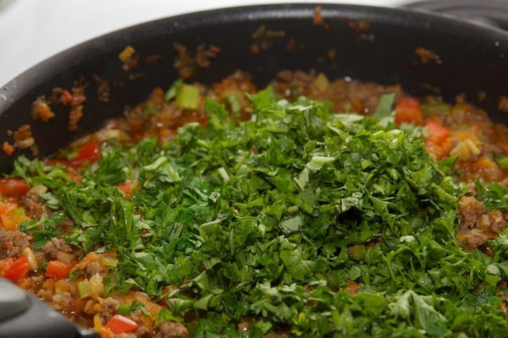 1. Этап. Лазанья с фаршем и овощами: 6. Когда начинка уже готова, последний штрих — это свежая зелень. В последний раз перемешайте и снимите сковороду с огня.