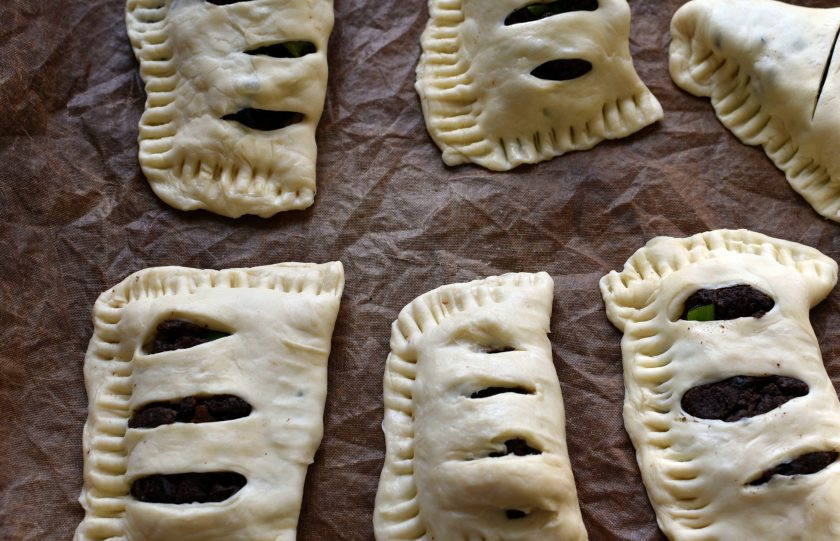 1. Этап. Заячьи потрошки в слоеном тесте: На одну половину квадрата выложите потрошки, на другой сделайте несколько надрезов, не задевая края. Накройте потрошки надрезанной половиной теста и хорошо защипайте. Для прочности и декора пройдитесь по краям вилкой.