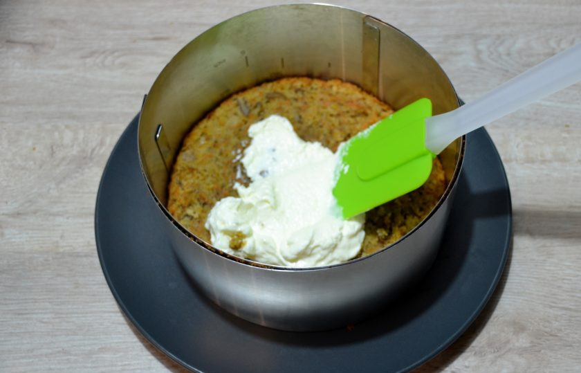 1. Этап. Морковный торт с вишней: Установите на блюдо кондитерское кольцо, в котором будете собирать торт, выложите первый корж, обильно смажьте сметанным кремом.