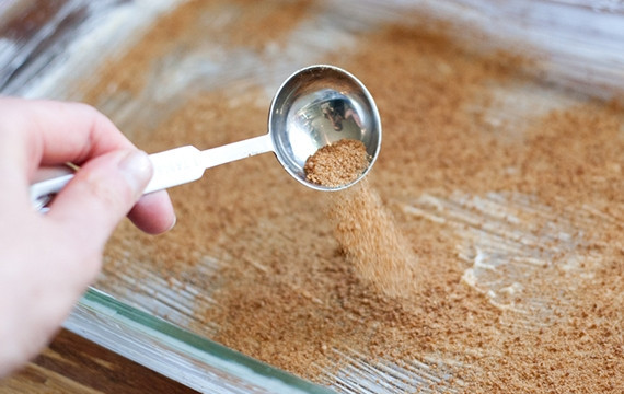 1. Этап. Запеченные яблоки с овсянкой: 2. Смажьте тщательно форму для запекания сливочным маслом и щедро посыпьте сахаром.