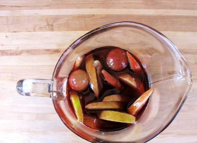 1. Этап. Сангрия ни сидре: 3. Нарежьте тонкими дольками грушу и яблоко. Фрукты вместе с виноградом добавьте в смесь из вина, бренди, ликёра и ванилина. Влейте сидр. Перемешайте.