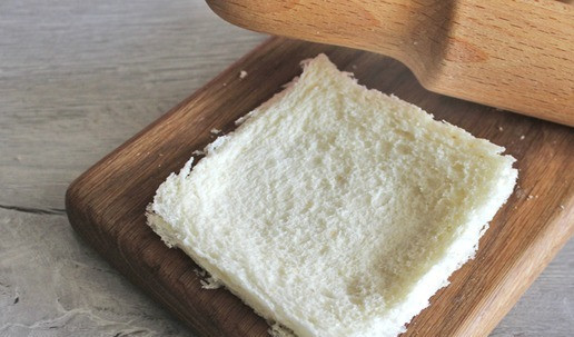 1. Этап. Омлет с хлебными рулетиками: Скалкой раскатать ломтик хлеба для тостов в тонкий пласт.