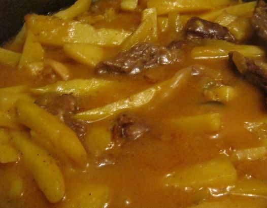 1. Этап. Говядина по-азербайджански: 4. Теперь добавим картофель, нарезанный тонкими брусочками, а также измельченные помидоры и зелень. Солим, перчим по вкусу. Ждем готовности картофеля.