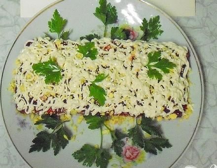 1. Этап. Рулет с сельдью на Старый Новый год: 6. Выкладываем на блюдо рулет, желтками вареных яиц посыпаем, украшаем майонезом и петрушкой.