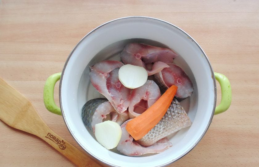 1. Этап. Заливное из пеленгаса: Добавьте очищенный репчатый лук и морковь.