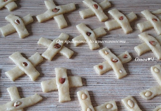 1. Этап. Печенье «Крестики» с орехами: Украсьте кусочками орехов, хорошо вдавливая в тесто.