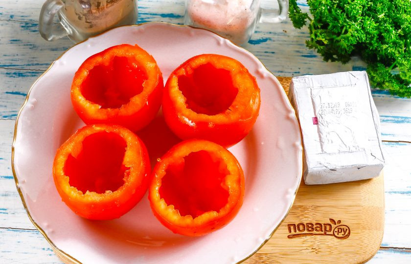 1. Этап. Помидоры с плавленным сыром и чесноком: Помидоры промойте в воде, срежьте с овощей крышечки и подрежьте с помощью ножа мякоть внутри, а затем извлеките ее чайной ложкой. Используйте не сочные сорта томатов, можно даже нафаршировать помидоры черри.