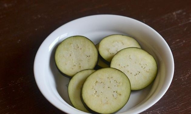 1. Этап. Баклажаны, запеченные с чесноком: Баклажаны вымойте и обсушите. Нарежьте их на кружочки около сантиметра толщиной. Посолите баклажаны и дайте им постоять, чтобы выделилась жидкость.