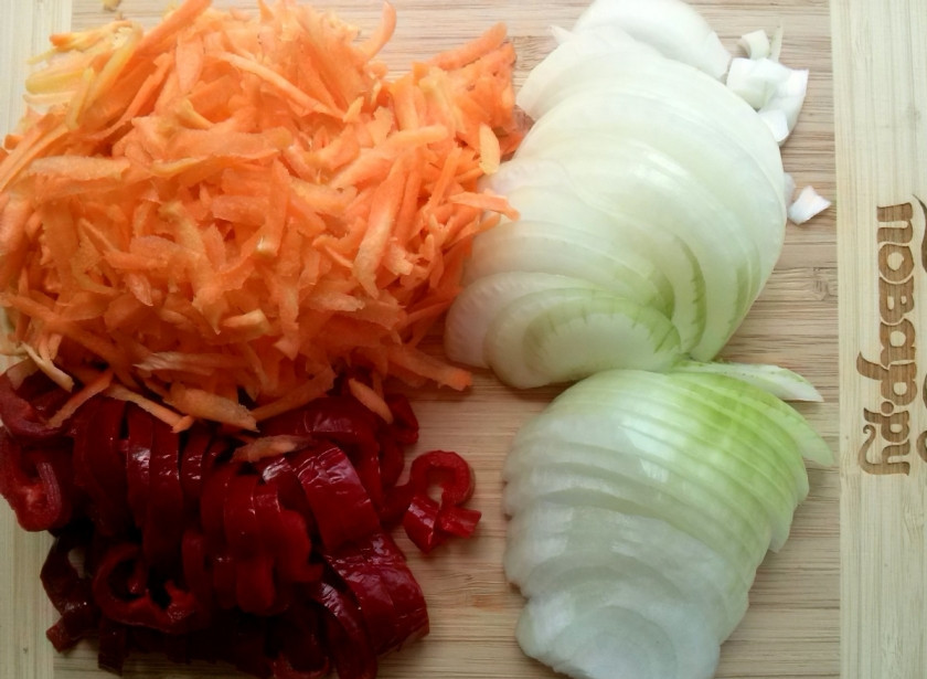 1. Этап. Чахохбили из курицы по-грузински: Лук и морковь очистите. Лук нарежьте полукольцами, морковь натрите на крупной терке. Болгарский перец очистите от сердцевины и нарежьте полосками.