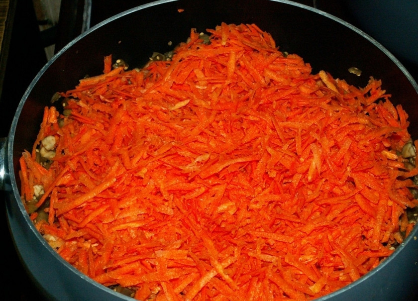 1. Этап. Фасоль консервированная на зиму: 3. Морковь очистите, натрите на средней терке и добавьте в кастрюлю к баклажанам.