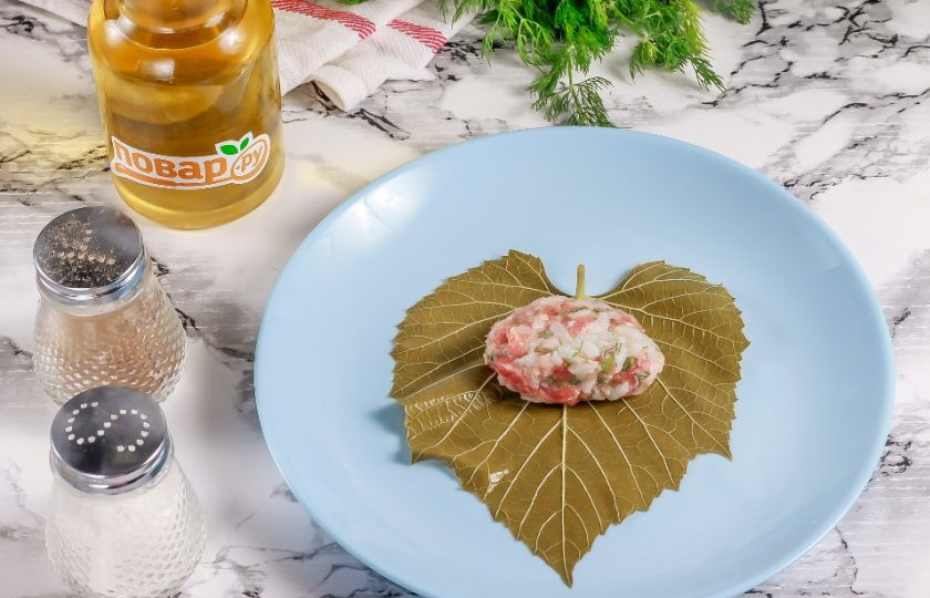 1. Этап. Долма с мятным соусом: Выложите виноградный лист на тарелку или доску. Скатайте в руках часть начинки и выложите на лист. Сверните бока листа и скатайте все рулетиком.