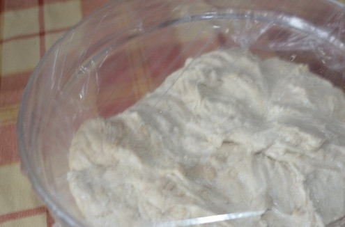 1. Этап. Домашний хлеб на закваске: Накройте получившееся тесто пищевой пленкой и оставьте в теплом месте, чтобы оно начало подниматься. Несколько раз обминайте тесто руками, когда оно достаточно поднимется.