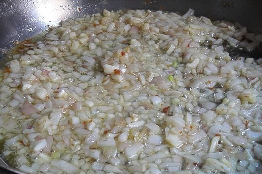 1. Этап. Курица Маренго: 3. Снимите курицу и временно отложите. А на сковороду отправьте измельченный лук с чесноком. Жарьте на среднем огне, помешивая, минуты 3-4.