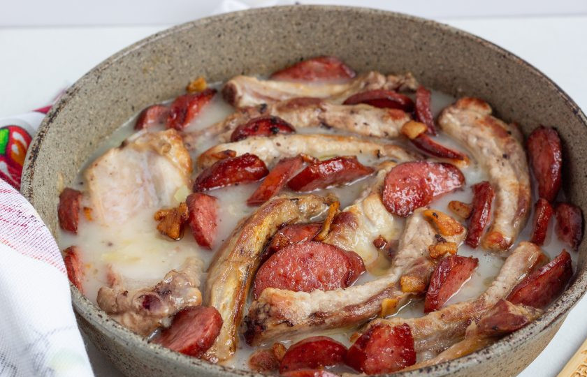 1. Этап. Пряженина: Выложите в соус ребрышки и колбасу, после закипания максимально уменьшите огонь и томите на медленном огне под крышкой один час. За пять минут до конца приготовления добавьте рубленный чеснок.