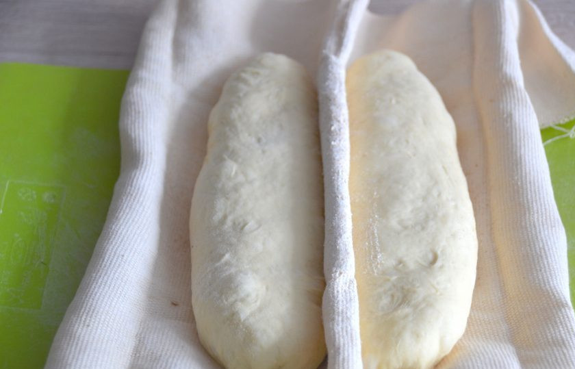 1. Этап. Батон на закваске: Выложите заготовки батонов на ткань, присыпанную мукой, 