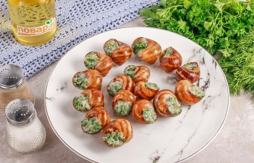 1. Этап. Виноградные улитки по-бургундски: Выложите в каждую ракушку немного сливочного масла, затем вложите отварную улитку и запечатайте отверстие ракушки сливочным маслом. В таком виде улитки можно заморозить как полуфабрикат.