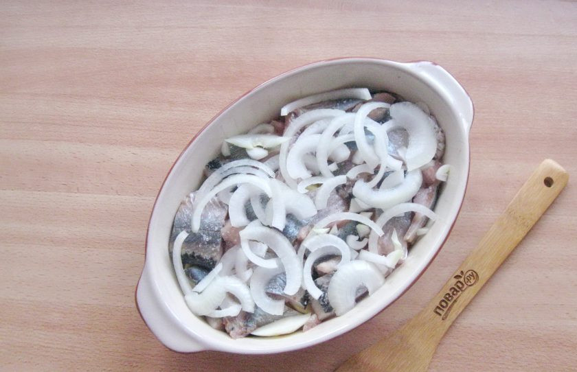 1. Этап. Калалаатикко: Репчатый лук очистите, помойте и нарежьте кольцами или полукольцами. Выложите на слой сельди.
