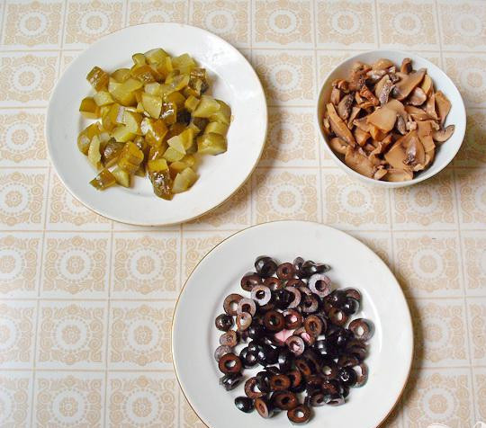 1. Этап. Солянка с ветчиной и грудинкой: 4. Колечками нарезаем маслины, небольшими кубиками режем соленые огурцы, пластинками нарезаем соленых грибов. В самом конце приготовления добавляем в кастрюлю грибы, маслины и соленые огурцы.