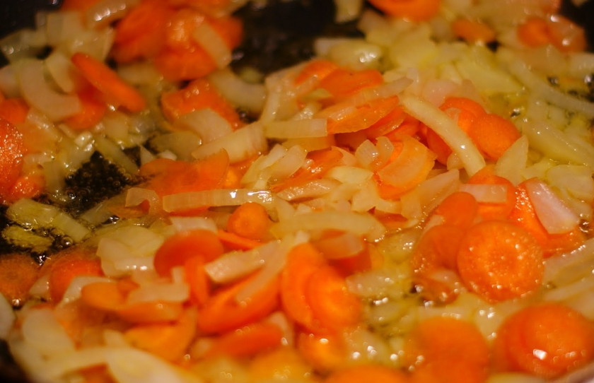 1. Этап. Овощи, жареные на сковороде: Ставим варить картофель, затем в глубокой сковороде или сотейнике обжариваем кольцами нарезанную морковь и крупно нарезанный лук. Обжариваем их около 5 минут, постоянно перемешивая.