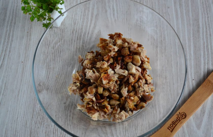 1. Этап. Салат с курицей и шампиньонами: В большую миску выложите обжаренные грибы, добавьте мелко нарезанное куриное мясо, предварительно отделенное от кости.