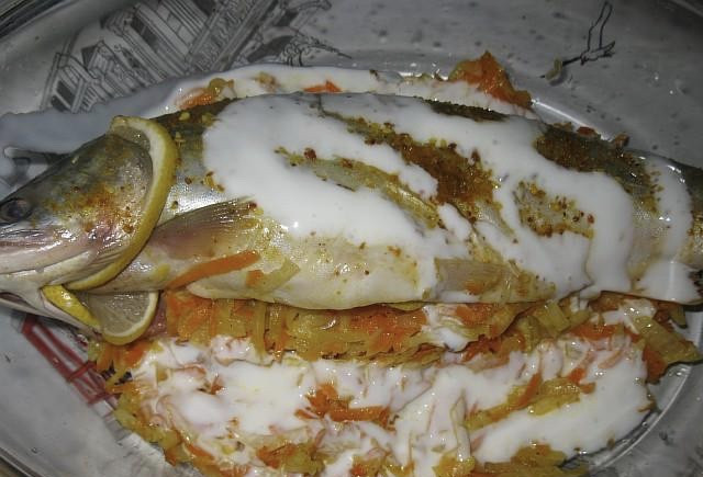 1. Этап. Голец в духовке: Теперь подготовленные овощи выкладываем внутрь рыбки, а также вокруг нее в форме, в которой будет готовится блюдо. Места, в которых у рыбки были жабры я люблю заполнять дольками лимона. Сверху всё поливаем кефиром.