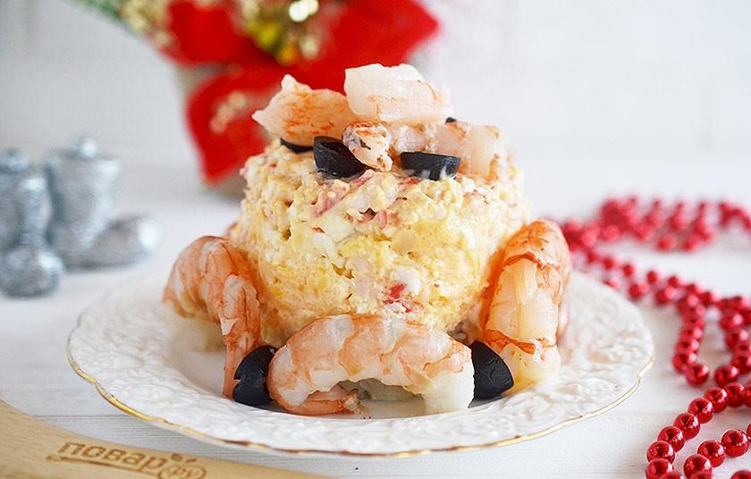 1. Этап. Новогодний салат Королевский: Креветки отварите на протяжении 5 минут, очистите. Украсьте салат сверху и сбоку креветками и маслинами.