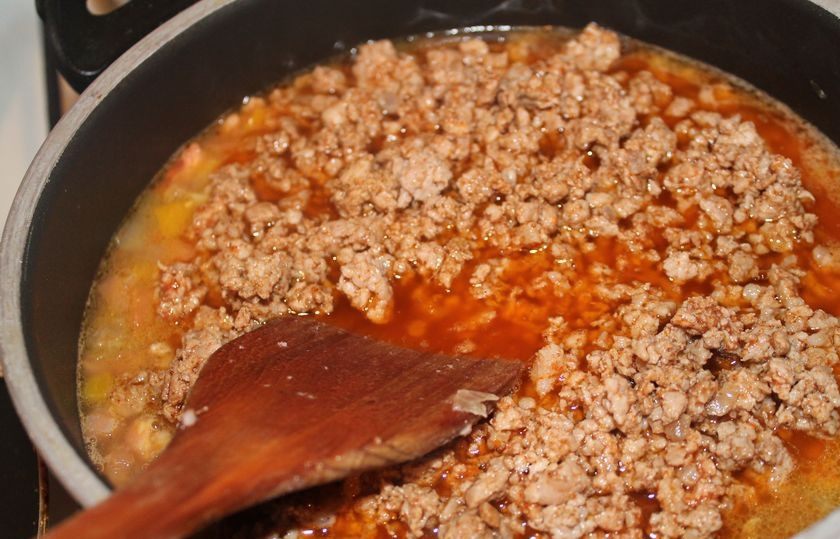 1. Этап. Мексиканский суп с фаршем: Когда фарш потеряет красный оттенок, добавляем в него по чайной ложке чили, кардамона и кумина и столовую ложку томатной пасты. Все тщательно перемешиваем и оставляем на огне буквально на 2 минуты.