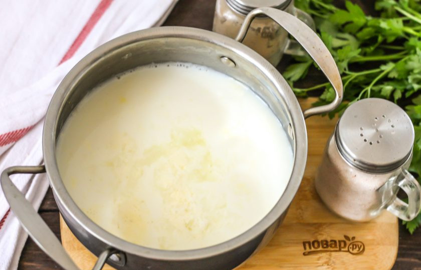 1. Этап. Сыр Рикотта из молока: Выжмите в кастрюлю с горячим молоком половину лимона, предварительно удалив косточки. Нагрев сразу же убавьте до умеренного, иначе при бурлении хлопья сыра снова расслоятся.