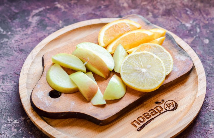 1. Этап. Безалкогольный коктейль на Новый год: Оставшийся апельсин нарежьте дольками. Также нарежьте дольками яблоко, лимон.