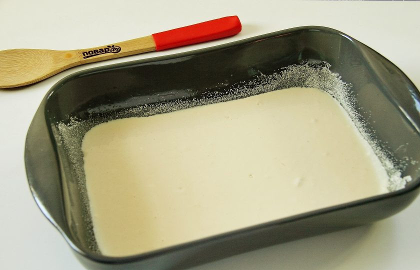 1. Этап. Студенческий пирог: Форму смажьте маслом, посыпьте дно и бока манкой или мукой. Вылейте половину теста и разравняйте его ложкой.