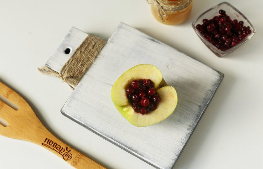 1. Этап. Запеченные яблоки с брусникой в духовке: В получившееся углубление выложите бруснику. Если ягода замороженная, то предварительно откиньте ее на сито, чтобы стекла вода.