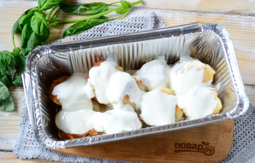 1. Этап. Тельное со сметаной: Готовые рыбные шарики сложите в форму для запекания, сверху полейте сметаной. Отправьте в духовку на 15-20 минут (температура — 200 градусов).