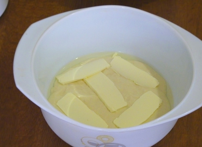 1. Этап. Заливной пирог с рыбой и яйцами: 5. Выливаем часть теста в емкость для запекания (у меня это керамическая форма с антипригарным покрытием, что очень важно). Выкладываем нарезанное сливочное масло.