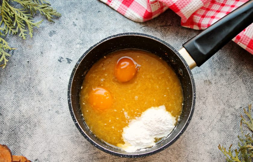 1. Этап. Морковный торт с апельсиновым курдом: Из апельсинов выжмите сок, удалите семечки и влейте в сотейник с сахаром. Добавьте в сотейник желтки и крахмал, перемешайте до однородности.