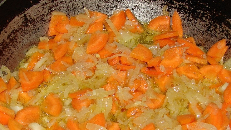 1. Этап. Свинина с картофелем: На сковороде разогреваем масло и выкладываем на него морковь и мелко нарезанный лук. Обжариваем на сильном огне до золотистой корочки.