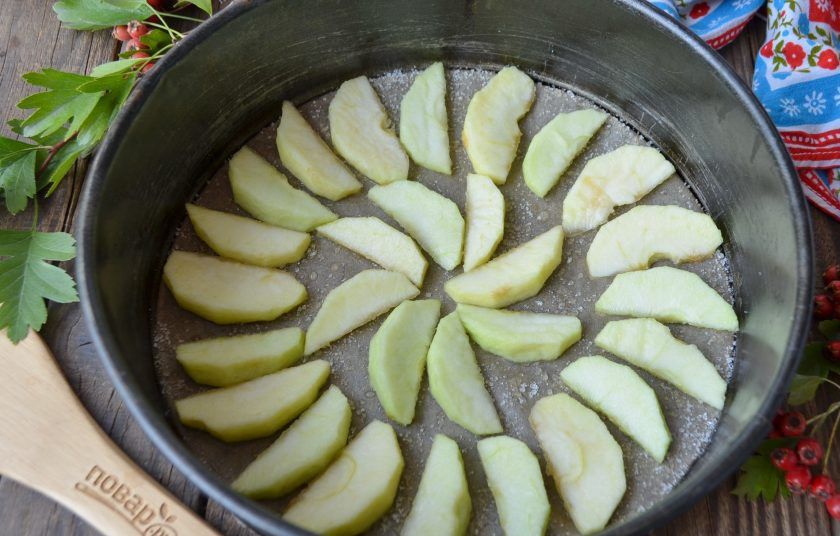 1. Этап. Пирог из кабачков и яблок: Форму застелите пергаментом, смажьте рафинированным маслом и присыпьте немного сахаром. Яблоки очистите от кожуры и сердцевины, порежьте дольками и уложите по кругу.