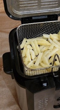 1. Этап. Картофель фри моей мечты: 6. Растительное масло необходимо залить во фритюрницу на 1/3. В среднем это 1,5–2 литра растительного масла. Фритюрницу нужно заранее прогреть до высокой температуры (около 180°C). Выложите ломтики картофеля в форму для обжаривания. Не заполняйте корзину на более чем 2/3, так как это может привести к неправильному нагреву и ломтики прожарятся неравномерно. Корзину для жарки прикрепите к краю фритюрницы так, чтобы картофель был полностью погружен в масло. Закройте крышку фритюрницы. Картофель должен жариться 2-3 минуты.